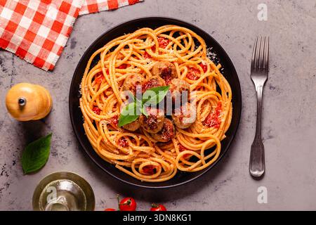 Spaghetti mit Fleischbällchen und Tomatensauce auf Steinhintergrund, Draufsicht Stockfoto