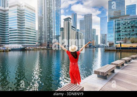 Eine glückliche Touristin auf einer Besichtigungstour genießt die moderne Skyline von London, England, an einem sonnigen Tag Stockfoto