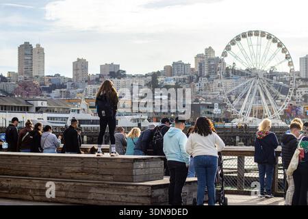 Touristen am Pier 39 in San Francisco, Kalifornien, mit SkyStar Wheel Ferris Wheel an Fisherman's Wharf im Hintergrund Stockfoto