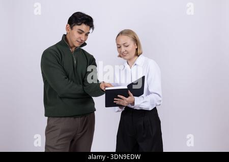Mann und Frau, die im Studio auf schwarzen Ordner schauen Stockfoto