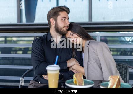 Pärchen sitzen am Café-Tisch und unterhalten sich miteinander Stockfoto