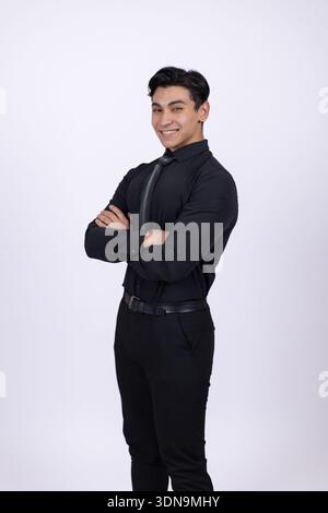 Junger Mann posiert mit einem selbstbewussten Lächeln im Studio Stockfoto