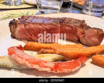 Mittelseltenes Steak mit knusprigem Tempura-Gemüse Stockfoto