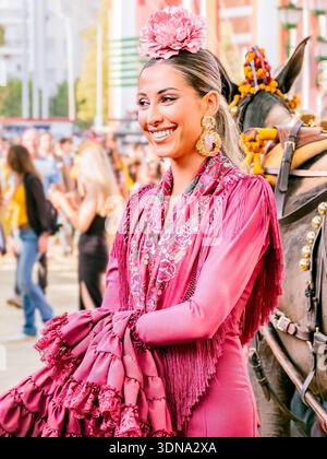 Frau in farbenfrohen Flamenco-Kleidern auf der festlichen Messe von Sevilla. Stockfoto