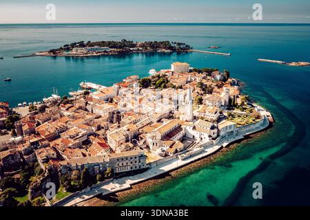 Blick aus der Vogelperspektive auf die Terrakotta-Dächer, die sich hinabstürzen und auf das türkisfarbene Wasser rund um die historische Altstadt, Poreč, Istrien County, Cro treffen Stockfoto