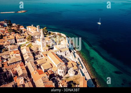 Aus der Vogelperspektive auf die Terrakotta-Dächer treffen auf die türkisfarbene Adria, eingerahmt vom Turm der Euphrasianischen Basilika, wo alte Steine Geschichten erzählen, Poreč, Stockfoto