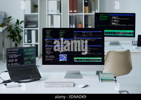 Büroschreibtisch, Auf Dem Computerbildschirme Mit Programmiercode Angezeigt Werden Stockfoto