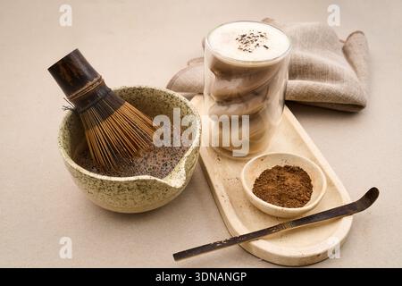 Hojicha Latte wird mit traditionellen Werkzeugen zubereitet und serviert eine moderne Version von geröstetem grünem Tee Stockfoto