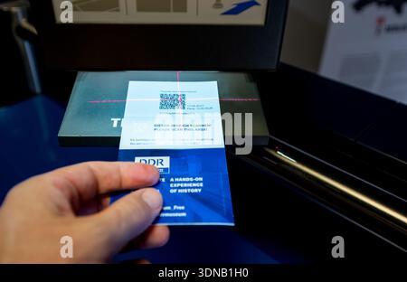 Berlin, deutschland, 12. august 2023. Person, die mit einem Laserscanner eine Papierkarte mit qr-Code für den Eintritt in das ddr-Museum in berli scannt Stockfoto