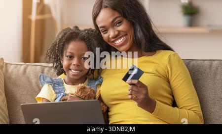 Mutter und Tochter kaufen tagsüber gemeinsam zu Hause online Stockfoto