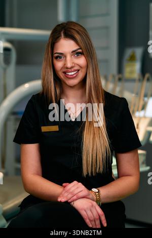 Freundlicher medizinischer Fachmann in Scrubs posiert für Porträt in moderner klinischer Umgebung Stockfoto