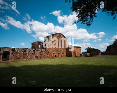 Panoramablick auf alte Ruinen in einem offenen Raum mit Gras im Vordergrund und blauem Himmel mit voluminösen Wolken. Ideal für Tourismus, Geschichte, Erbe Stockfoto