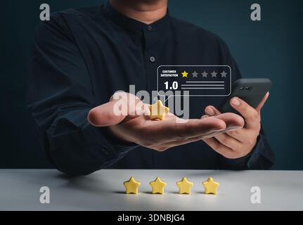 Ein Mann, der mit einem Stern bewertet und kommentiert, während er das Smartphone verwendet, zeigt eine geringe Kundenzufriedenheit und ein negatives Feedback-Konzept. Schlechte Bewertung des Service, Profi Stockfoto