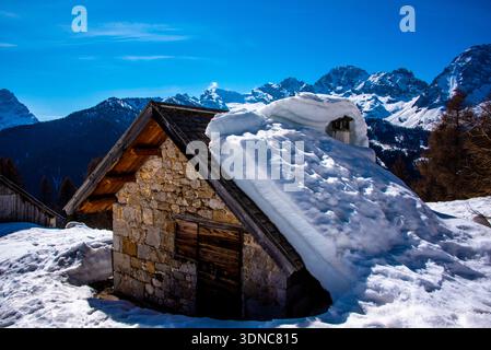 Kleine schneebedeckte Hütte an den Hängen der dolomiten des val di Zoldo, Belluno, Italien Stockfoto