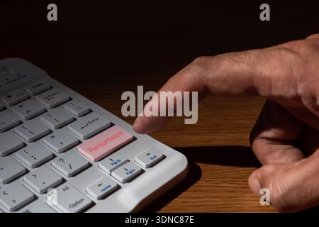 Nahaufnahme eines Fingers, der eine Ransomware-Taste auf einer weißen Computertastatur drückt. Cyberkriminalität, Hacking, Bedrohungen der Datensicherheit und Cybererpressung. Stockfoto