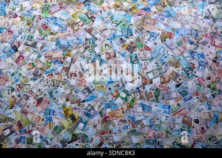 Viele Banknoten unterschiedlicher Währung. Eine große Menge von zufälligen Geldrechnungen aus der Nähe. Währungsumtausch-Konzept Stockfoto