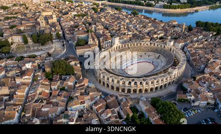 Frankreich, Bouches du Rhone, Arles, die Arena, ein römisches Amphitheater, erbaut um 80-90 n. Chr., und das antike Theater aus dem 1. Jahrhundert v. Chr. links, das von der UNESCO zum Weltkulturerbe erklärt wurde, im Herzen der Altstadt und der Rhone im Hintergrund (Luftaufnahme) Stockfoto