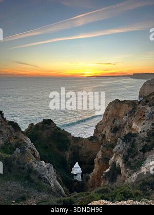 Goldener Sonnenuntergang über den Küstenklippen von Ponta da Piedade und dem Meeresbogen in Lagos, Faro, Portugal, Februar 2025 Stockfoto