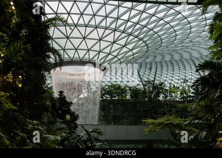 Singapur - 11. Januar 2026: Besucher genießen den Blick auf einen großen Indoor-Wasserfall, der von der Decke des Jewel Changi Airport herabstürzt. Die Stockfoto