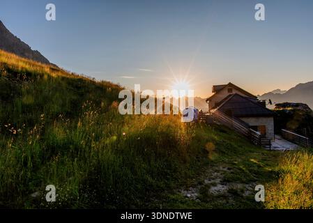 Sonnenaufgang zwischen den Gipfeln der Belluno Alpen mit Weidewiesen Sonnenaufgang auf den Belluno Dolomiten in Gossaldo Belluno Veneto Italien Europa Stockfoto