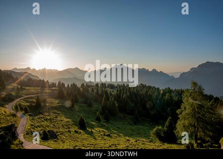 Sonnenaufgang zwischen den Gipfeln der Belluno Alpen mit Weidewiesen Sonnenaufgang auf den Belluno Dolomiten in Gossaldo Belluno Veneto Italien Europa Stockfoto