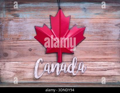 Word canada mit Ahornblatt auf hölzernem Hintergrund Stockfoto