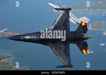 Die belgische F-16AM FA-87, Serie 6H-87, und die Schweizer F/A-18C J-5008, Serie 1336/SFC008, führen auf der Turku Airshow 2023 Kunstflug durch, einschließlich Banking- und Zoom-Klettertouren. F-16AM mit Turbofan F100-PW-220 und F/A-18C mit Motoren F404-GE-402 demonstrieren Multifunktionsleistung, Agilität und Fluggenauigkeit. Luft-Luft-Ansichten und Nahperspektiven aus Piloten heben Handling, Kunstflug und Displaylackierung mit Heckkunst hervor. Stockfoto