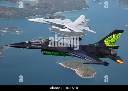 Die belgische F-16AM FA-87, Serie 6H-87, und die Schweizer F/A-18C J-5008, Serie 1336/SFC008, führen Kunstflugzeuge auf der Flugschau Turku 2023 durch. F-16AM mit F100-PW-220-Motor und F/A-18C mit F404-GE-402-Motoren demonstrieren Agilität, Präzision und überschallbare Multifunktionsleistung. Luft-Luft-Perspektiven und Nahaufnahmen der Piloten betonen Flugsteuerung, Handling und Kunstflugzeug mit individueller Lackierung und Heckkunst. Stockfoto