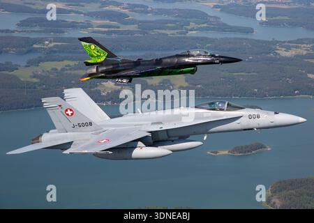 Belgische F-16AM 'Dream Viper', Reg. FA-87 und Swiss F/A-18C Hornets, Reg. J-5008 und J-5016 führen Kunstflugzeuge auf der Turku Airshow 2023 in Finnland durch. Niedriger Flügel, Luftpolsterdach, Multifunktionskonfiguration, benutzerdefinierte Lackierung, Tail Art, Rumpf, Steuerflächen und Wingtip-Manövrieren sind hervorgehoben. Air-to-Air-Display zeigt Flugpräzision, Leistung und Demonstrationsmöglichkeiten für die öffentliche Luftfahrt für Mehrzweckjäger. Stockfoto