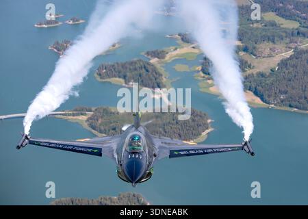 Eine Nahaufnahme der belgischen Luftwaffe F-16AM im Kampf gegen Falcon FA-87 während einer Einzelausstellung auf der Turku Airshow in Finnland 2023. Der General Dynamics Fighter wird von einem Pratt & Whitney F100 Turbofan-Motor angetrieben und trägt die Dream Viper-Gedenklackierung. Rauch aus dem Anzeigesystem zeichnet das Kunstflugmanöver des Flugzeugs nach. Das Cockpit und der Pilot sind deutlich sichtbar, während der Jet eine offizielle militärische Flugdemonstration durchführt. Stockfoto