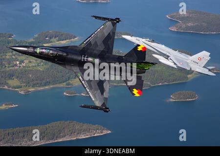 Die belgische F-16AM FA-87, Serie 6H-87, mit der Schweizer F/A-18C J-5008, Serie 1336/SFC008, führen auf der Turku Airshow 2023 Kunstflugmanöver durch. F-16AM mit F100-PW-220 und F/A-18C mit F404-GE-402 Motoren. Nahaufnahmen von Piloten und Luft-Luft-Perspektiven zeigen Agilität, Präzision und betriebliche Multirollenleistung mit Displaylackierung und Tail Art. Stockfoto