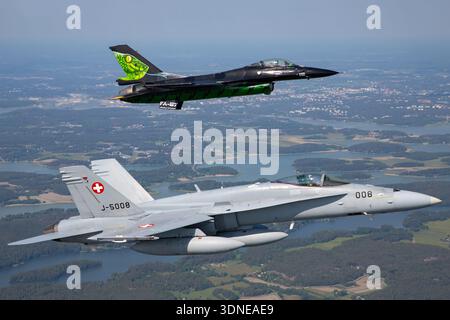 Belgische F-16AM 'Dream Viper', Reg. FA-87 und Swiss F/A-18C Hornets, Reg. J-5008, Auftritt als Solo- und Formationsflugzeug auf der Turku Airshow 2023. Flugzeuge verfügen über Tiefflügel-Konfiguration, Luftpolsterdach, individuelle Lackierung, Heckbild, Rumpf, Steuerflächen, Flügelspitze und fortschrittliche Avionik. Die Air-to-Air-Demonstration konzentriert sich auf die Flugmanövrierfähigkeit, Präzision, Leistung und öffentliche Demonstrationsmöglichkeiten von Mehrzweckjägern. Stockfoto