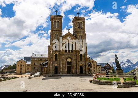 Eine majestätische Steinkirche vor dem Hintergrund schneebedeckter Berge und eines lebendigen Himmels. Stockfoto