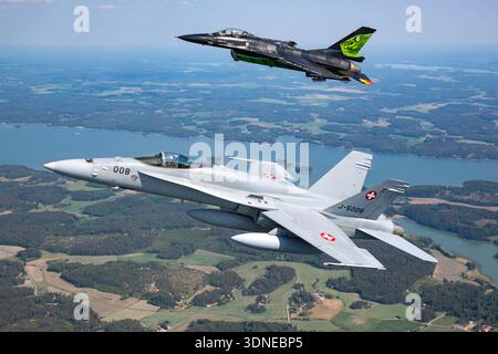 Die belgische F-16AM FA-87 und die Schweizer F/A-18C Hornet J-5008 werden auf der Turku Airshow 2023 gezeigt und führen Präzisionsflugzeuge auf Solo- und Formationsflügen durch. Flugzeuge zeigen kundenspezifische Farben und Heckbilder. Die F-16AM arbeitet mit einem Pratt & Whitney F100-PW-220 Turbofan und die F/A-18C Hornet arbeitet mit zwei General Electric F404-GE-402-Motoren. Nahaufnahmen von Piloten und Luft-Luft-Winkel veranschaulichen Flugmanöver und -Leistung. Stockfoto