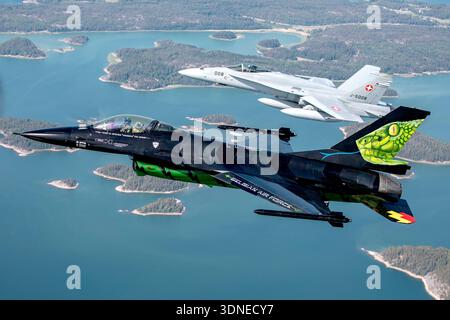 Die belgische Luftwaffe F-16AM, die Falcon FA-87 und die Schweizer Luftwaffe F/A-18C Hornet J-5008 werden während eines Formationspasses auf der Flugschau Turku 2023 in Finnland gefangen genommen. Der einmotorige F-16AM verfügt über einen Pratt & Whitney F100 Turbofan und trägt die Dream Viper Displaymarkierungen mit Rauch. Der zweimotorige F/A-18C Hornet wird von General Electric F404 Turboventilatoren angetrieben. Das Bild dokumentiert eine präzise militärische Kunstflugdemonstration. Stockfoto