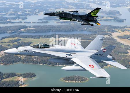 Belgische F-16AM 'Dream Viper', Reg. FA-87 und Swiss F/A-18C Hornets, Reg. J-5008 und J-5016 führen Solo- und Formationsflugzeuge auf der Turku Airshow 2023 auf. Mit Luftblasen-Vordächern, niedrigen Flügeln, Multifunktionsfunktionen und einer individuellen Lackierung mit Heckdesign demonstrieren diese Flugzeuge Luftmanövrieren, Flügelkonfiguration, Rumpfstruktur und Steuerflächen während öffentlicher Demonstrationsflüge. Stockfoto