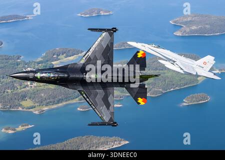 Belgische F-16AM 'Dream Viper', Reg. FA-87 und Swiss F/A-18C Hornets, Reg. J-5008 und J-5016 führen auf der Turku Airshow 2023 Kunstflugmanöver durch. Die Multifunktionsjäger verfügen über eine niedrige Flügelkonfiguration, eine Luftblase, eine spezielle Lackierung, fortschrittliche Avionik, Rumpf, Flügel und Steuerflächen. Das Air-to-Air-Display zeigt Manövrierfunktionen, Flugleistung und Demonstrationsmöglichkeiten für die öffentliche Luftfahrt. Stockfoto