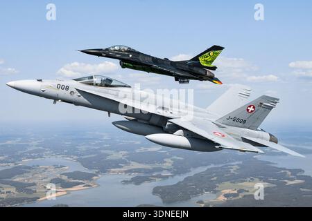 Belgische Luftwaffe F-16AM „Dream Viper“, Reg. FA-87 und Swiss F/A-18C Hornets, Reg. J-5008 und J-5016 führen Kunstflugzeuge auf der Turku Airshow 2023 in Finnland durch. Das Flugzeug verfügt über Tiefflügel-Designs, Luftpolsterdächer, Multifunktionsfähigkeiten, individuelle Lackierung, Heckkunst, und fortschrittliche Avionik. Das Air-Air-Display betont die Flügelkonfiguration, den Rumpf, die Steuerflächen und das präzise Manövrieren während der Demonstration der öffentlichen Luftfahrt. Stockfoto