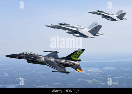 Belgische Luftwaffe F-16AM Fighting Falcon 'Dream Viper', Reg. FA-87, Seriennr. 6H-87, und F/A-18C Hornets der Schweizer Luftwaffe, Reg. J-5008 und J-5016, Seriennummern 1336/SFC008 und 1363/SFC016, führen Formationsflugzeuge auf der Turku Airshow 2023 in Finnland durch. Beide Mehrzweckkämpfer verfügen über eine individuelle Lackierung, eine Heckart, eine Tiefflügelkonfiguration, ein Luftpolsterdach und eine fortschrittliche Avionik. Das Air-to-Air-Display zeigt Manövrieren, Flügelspitzenbildung, Rumpf, Steuerflächen und Flugleistung während einer Demonstration in der öffentlichen Luftfahrt. Stockfoto