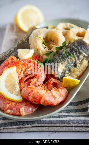 Gebratene Meeresfrüchte-Platte mit knusprigen Garnelen, Calamari-Ringen und Aal mit Zitrone Stockfoto