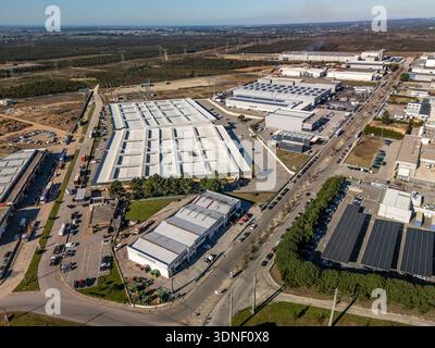 Aus der Vogelperspektive eines weitläufigen Industriegebiets mit geometrischen Dächern vor dem Hintergrund eines dichten Waldes, Albergaria-a-Velha, Portugal. Stockfoto