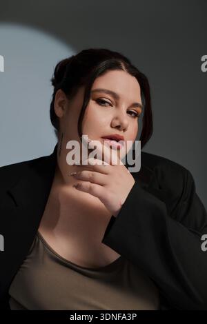 Die schöne Frau vereint ihren Stil in einem atemberaubenden Outfit, das Selbstvertrauen und Charme ausstrahlt. Stockfoto