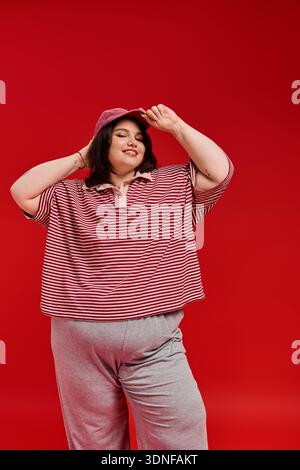 Eine Frau in Übergröße zeigt ihr Gespür für Mode, lächelt und posiert spielerisch mit Stil. Stockfoto