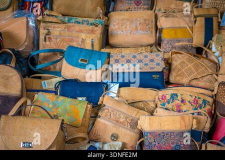 Funchal, Madeira, Portugal, 7. November 2024: Sehen Sie sich typische portugiesische Korkhandtaschen zum Verkauf auf dem Mercado dos Lavradores, Bauernmarkt, in Funchal an Stockfoto