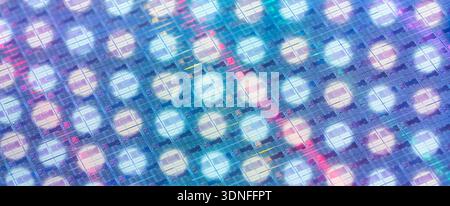 Hintergrund von Siliziumwafern mit Mikrochips, die verschiedene Farben widerspiegeln, die in der Elektronik zur Herstellung integrierter Schaltungen verwendet werden Stockfoto