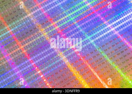 Hintergrund von Siliziumwafern mit Mikrochips, die verschiedene Farben widerspiegeln, die in der Elektronik zur Herstellung integrierter Schaltungen verwendet werden Stockfoto