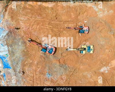 Bagger auf Erdbewegungsarbeiten auf Baustelle, Draufsicht. Stockfoto