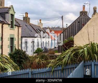 Farbenfrohe Häuser säumen eine Straße in Seatown, dem alten Fischerdorf Cullen an der Moray Coast, Schottland. Der Himmel ist grau und wirft ein sanftes Licht Stockfoto