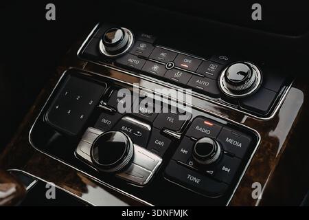 Nahaufnahme des Audiobedienfelds eines Autos mit Tasten und Knöpfen. Stockfoto