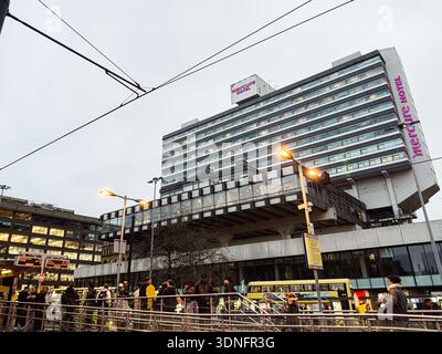 Manchester, Großbritannien - 22. Januar 2026: Publikum vor einem modernen Manchester Mercure Hotel, Großbritannien, unter erhöhten Gehwegen und Straßenlaternen. Stockfoto